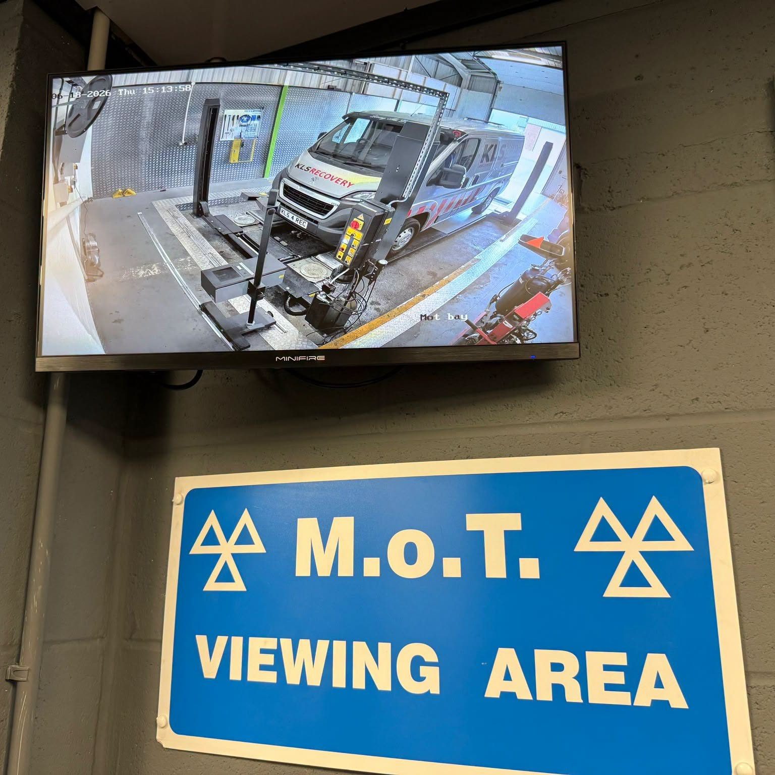 The MOT viewing area sign under a screen showing the test bay