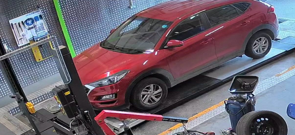 A red SUV on the MOT test bay